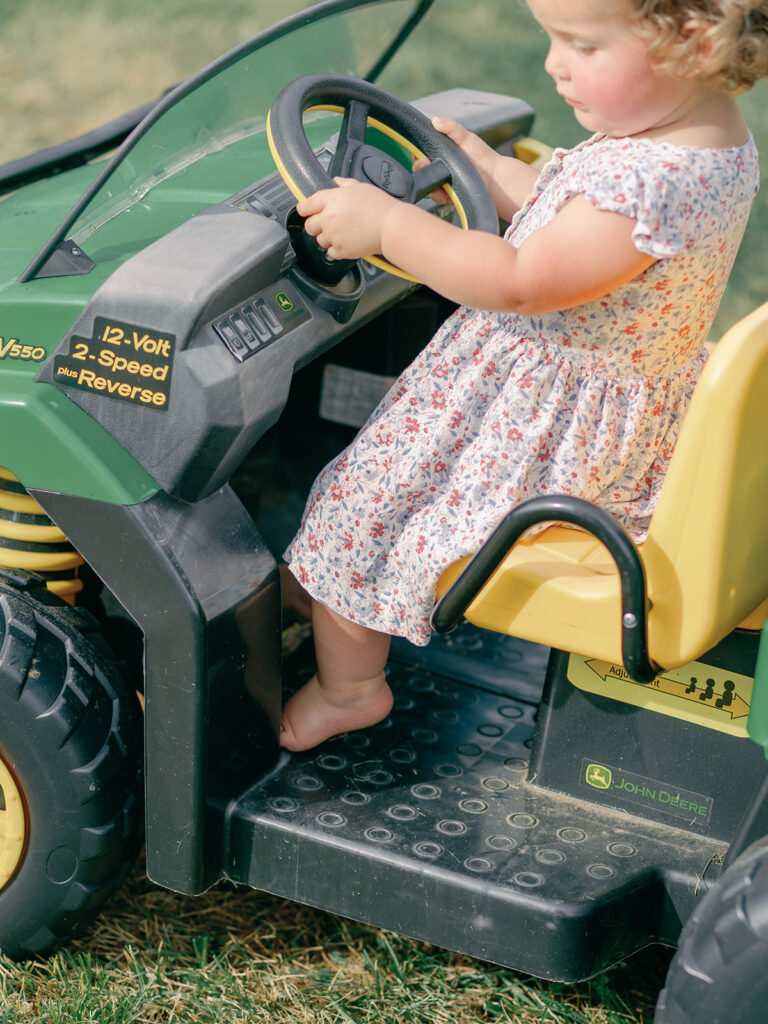 little girl riding john deer 