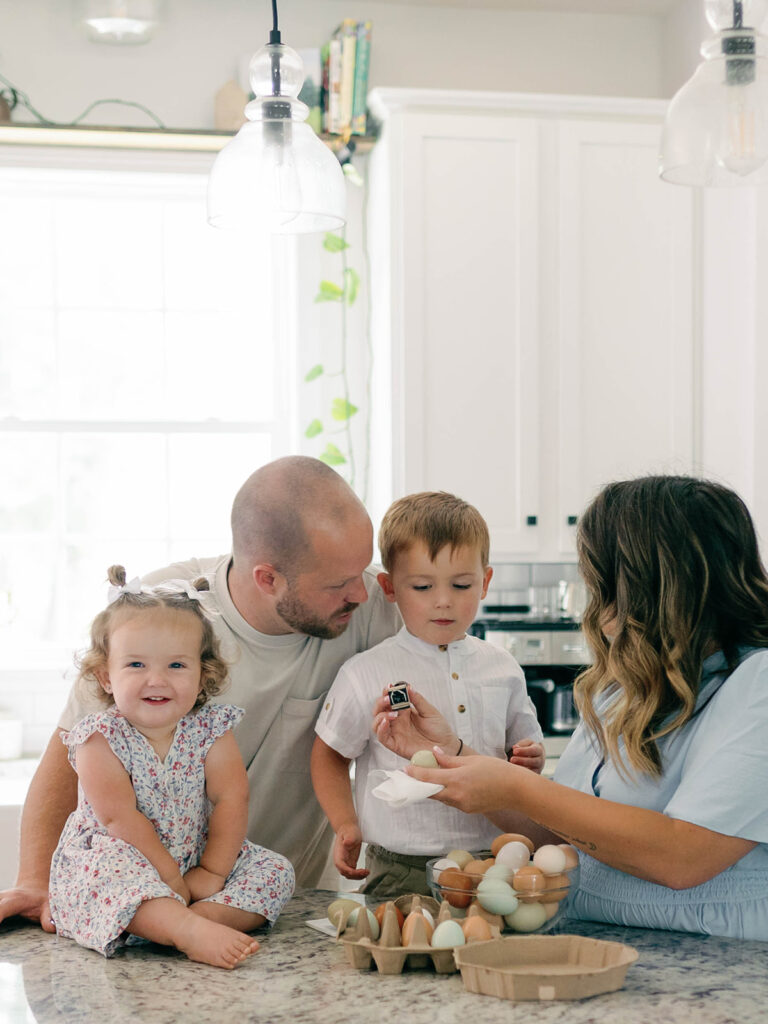 family stamping eggs in kitchen