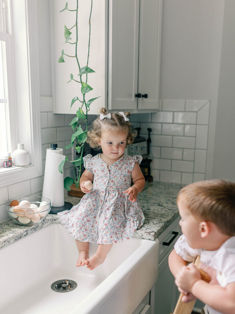 siblings playing in the kitchen sink