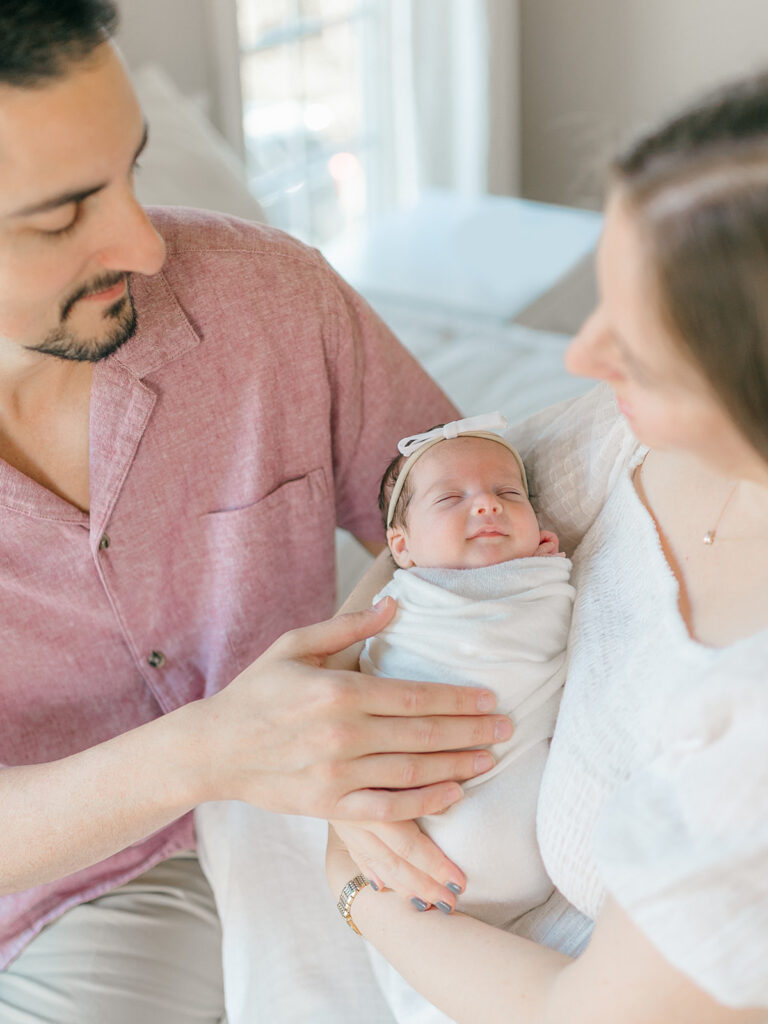 parents holding newborn baby girl