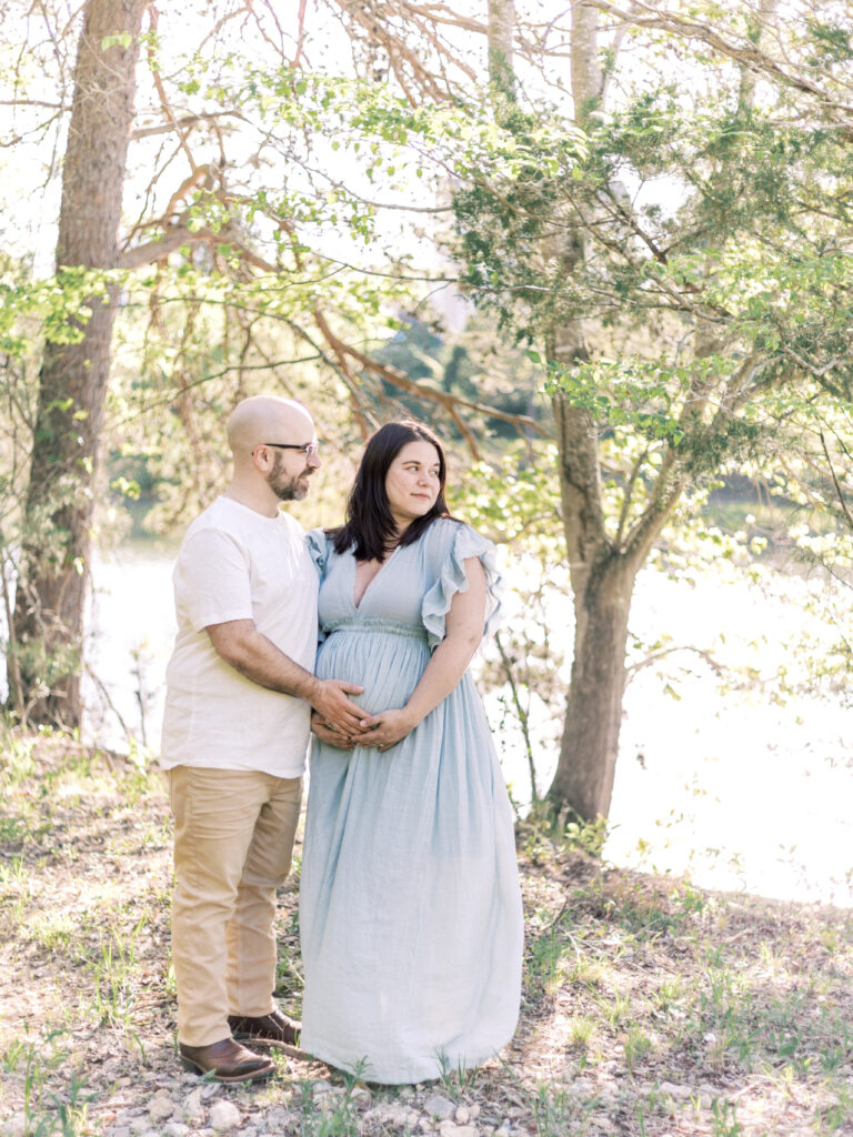 husband and pregnant wife looking at pond