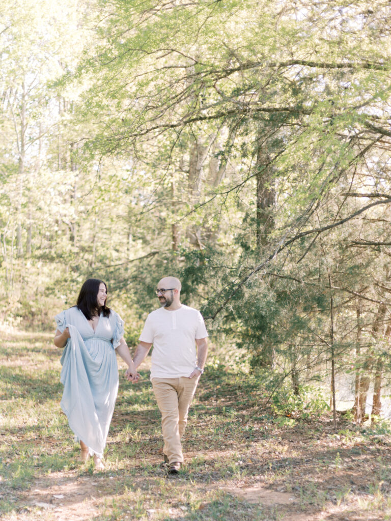 pregnant wife walking with husband in nature. 